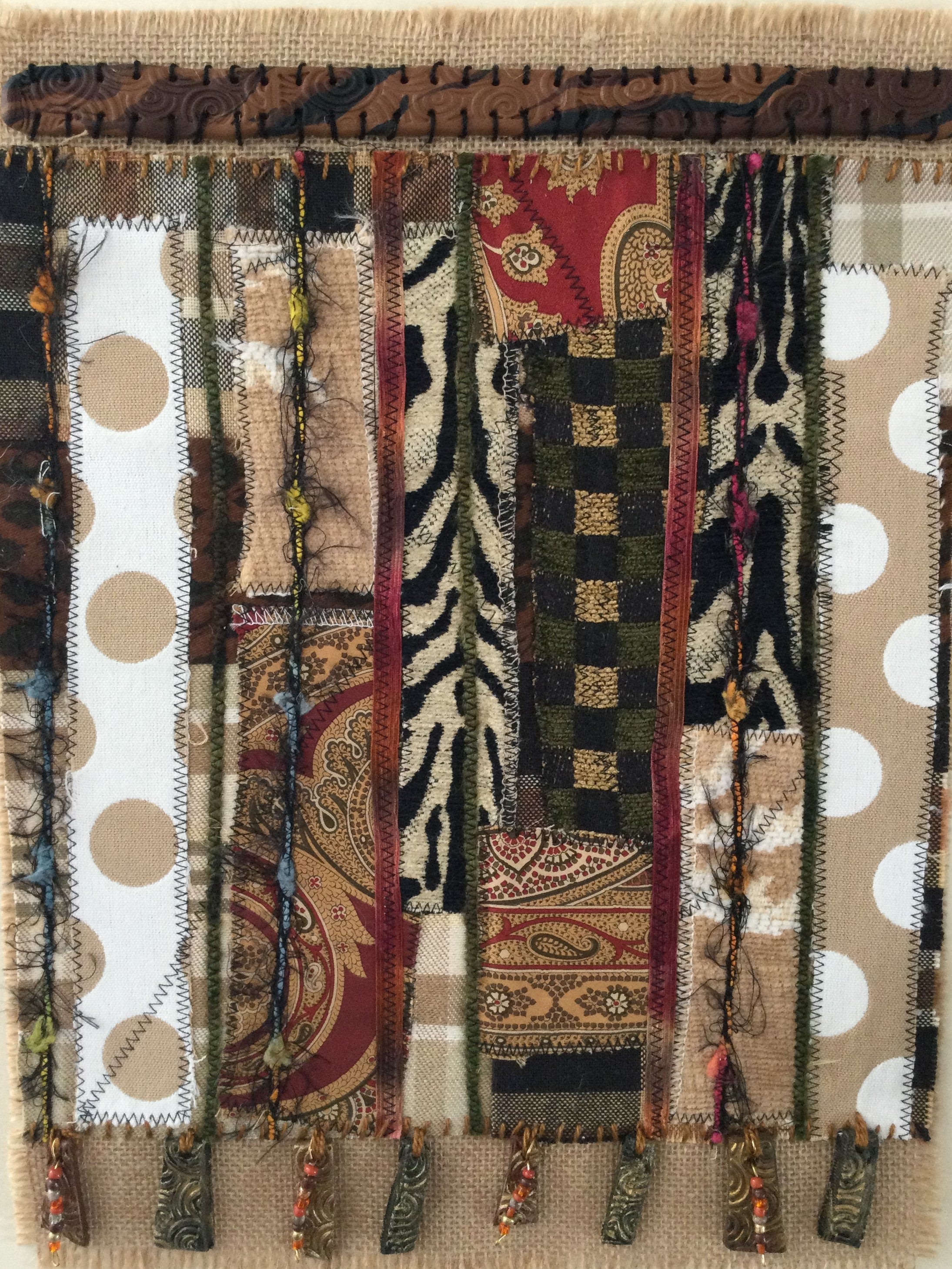 Textile with various patterns and earthen colors on a woven background